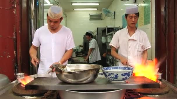 Los hombres preparan comida tradicional china en llamas en un mercado callejero de alimentos en Xian, China . — Vídeo de stock