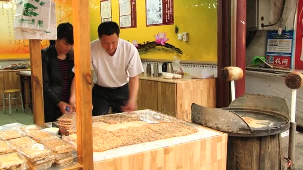 Uomo confezioni dolci alla bancarella in un mercato di street food a Xian, Cina . — Video Stock