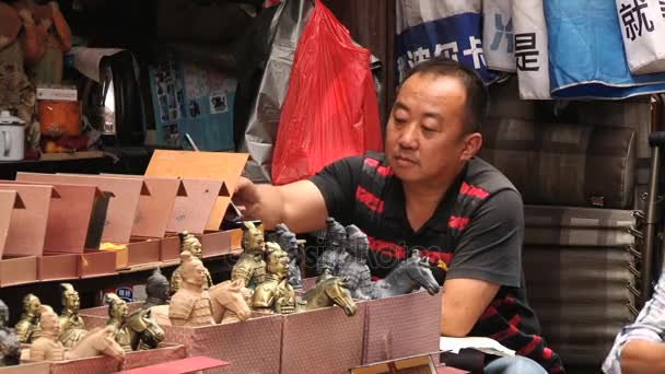 Person sælger traditionelle souvenirs på shoppinggaden i Xian, Kina . – Stock-video