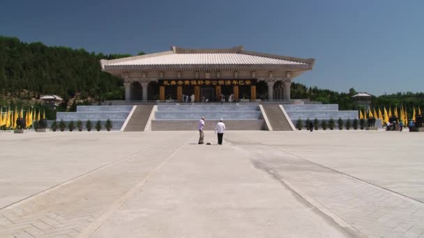 La gente hace fotos de viajes con la tumba de Qin Shi Huang al fondo en Xian, China . — Vídeos de Stock