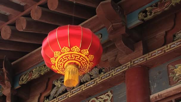 La tradicional linterna china roja cuelga con un fondo de madera tallada y pintada envejecida en Xian, China . — Vídeo de stock