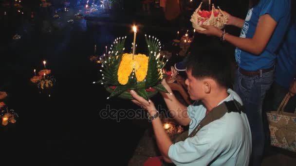 As pessoas rezam e colocam velas flutuantes na água durante as celebrações de Loi Krathong em Sukhothai, Tailândia . — Vídeo de Stock
