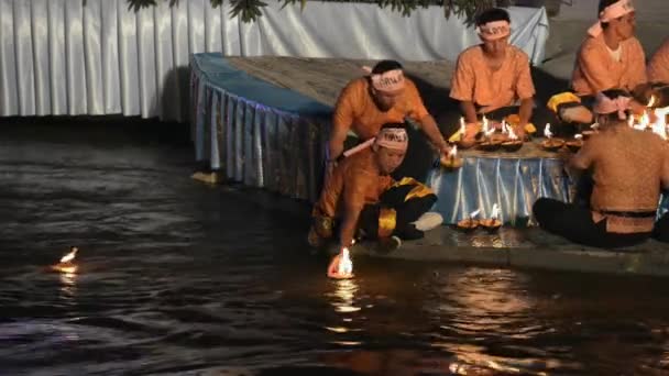 As pessoas colocam velas de casca de coco em chamas na água durante a celebração Loi Krathong em Tak, Tailândia . — Vídeo de Stock