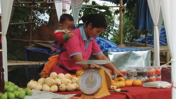 Kvinne selger grønnsaker på markedet på Doi Mon Jam Royal Agricultural Station, Thailand . – stockvideo