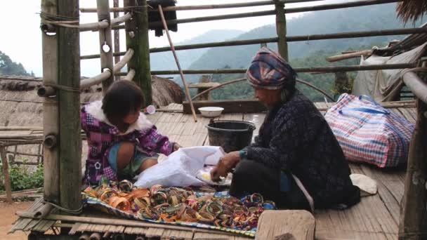 Mujer produce recuerdos tradicionales de la tribu de la colina en Doi Ang Khang, Tailandia . — Vídeos de Stock