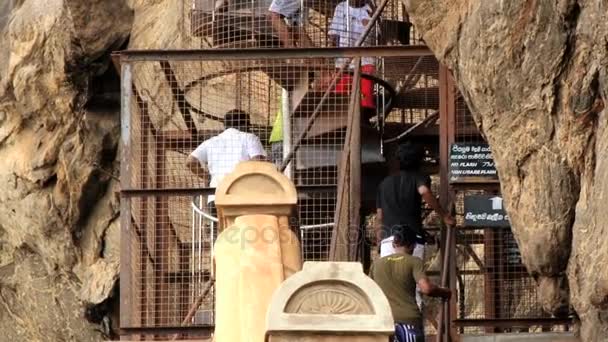 La gente sube por las escaleras para visitar las ruinas de la antigua fortaleza rocosa de Sigiria en Sigiriya, Sri Lanka . — Vídeo de stock