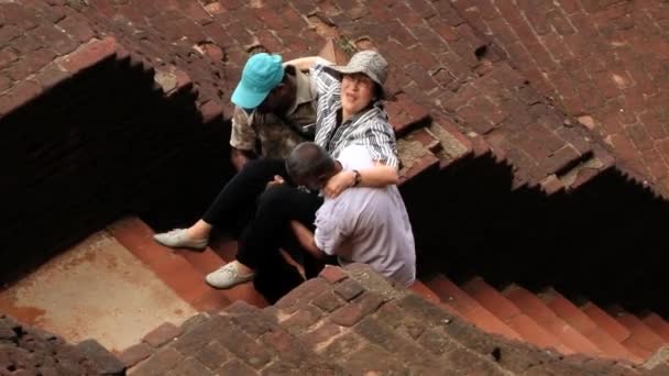 Människor ta på övervåningen en handikappad person att besöka ruinerna av den antika Sigiriya rock fästningen i Sigiriya, Sri Lanka. — Stockvideo