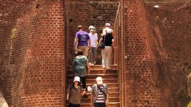 Ludzie wspiąć się i zejść po schodach, zwiedzanie ruin starożytnej twierdzy rock Sigiria w Sigiriya, Sri Lanka. — Wideo stockowe