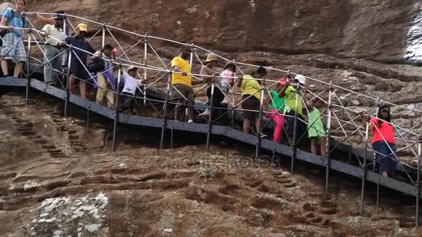 La gente desciende por las escaleras después de visitar las ruinas de la antigua fortaleza rocosa de Sigiria en Sigiriya, Sri Lanka . — Vídeos de Stock