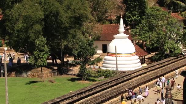 People walk by the territory of the Temple of Tooth (Dalada Maligava) in Kandy, Sri Lanka. — Stock Video