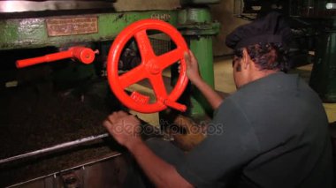 Adam eski çay kesme makinesi ile Nuwara Eliya, Sri Lanka çay fabrikasında çalışıyor.