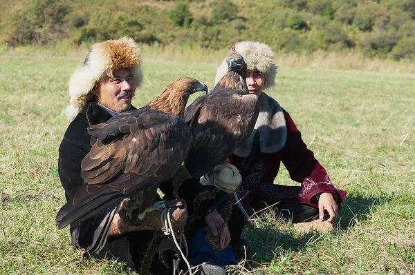 Men hold golden eagles (Aquila chrysaetos), Almaty, Kazakhstan. — Stock Photo, Image