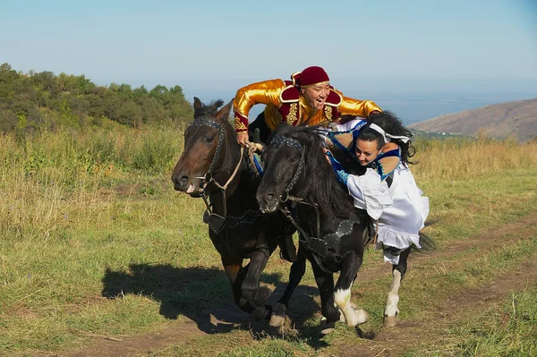 Människor bär nationella klänningar rida på landsbygden, Almaty, Kazakstan. — Stockfoto
