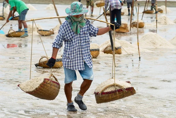 Man carries salt at the salt farm in Huahin, Thailand. — Stock Photo, Image