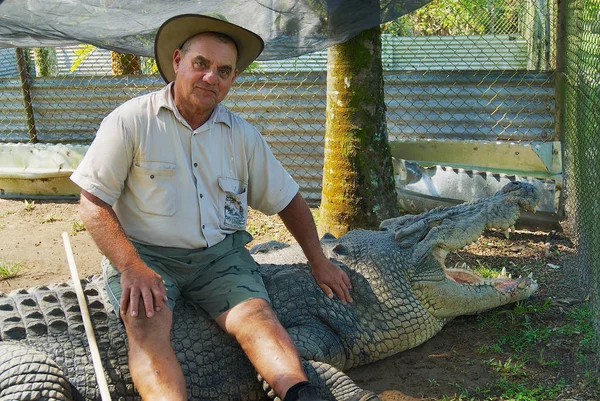Crocodile farmer Mick Tabone sits on the biggest monster reptile kept behind fence in Australia in Jonston River, Australia. — Stock Photo, Image