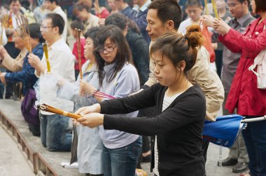 Tapanların tütsü sopa tutun ve Pekin, Çin Yonghegong Lama Tapınağı'nda dua.