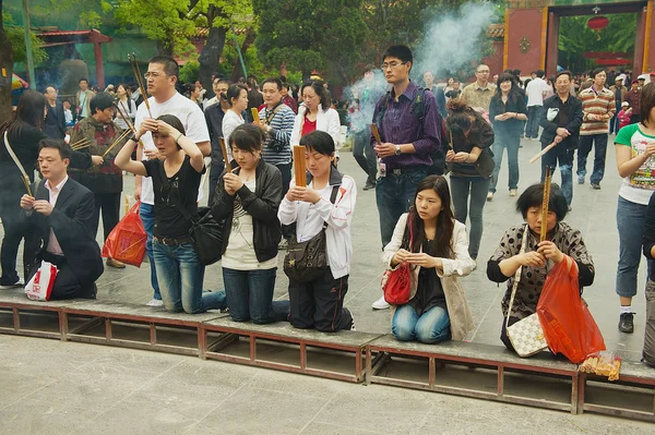 Tapanların tütsü sopa tutun ve Pekin, Çin Yonghegong Lama Tapınağı'nda dua.