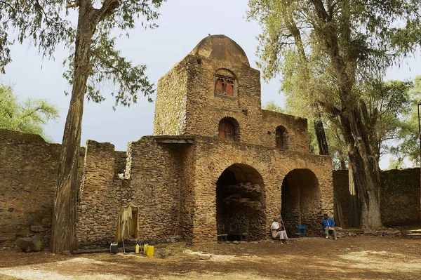 La gente se sienta frente a la entrada del territorio de la iglesia Debre Berhan Selassie en Gondar, Etiopía . —  Fotos de Stock