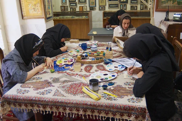 Muslim women artists in black headscarfs paint traditional Persian miniature in a workshop in Isfahan, Iran. — Stock Photo, Image