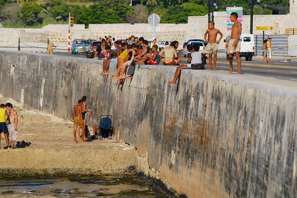 La gente prende il sole alla diga Malecon a L'Avana, Cuba . — Foto Stock