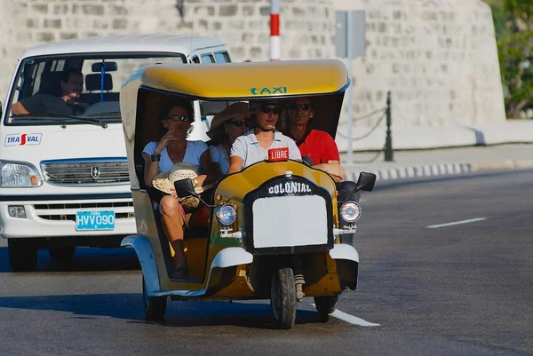 Los turistas disfrutan de un viaje en moto taxi, conocido como Coco taxi, en la avenida Malecón en La Habana, Cuba . —  Fotos de Stock
