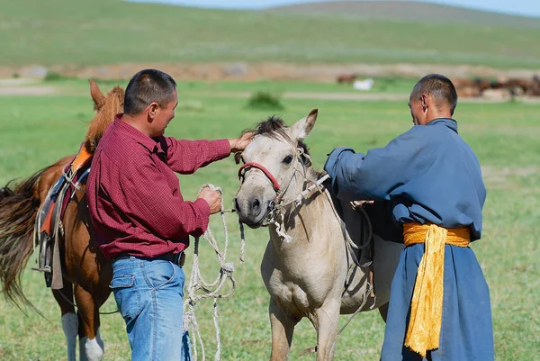 正体不明のモンゴル人が年頃ハルホリン モンゴルの馬に手綱を置くハルホリン モンゴル 2006 — ストック写真