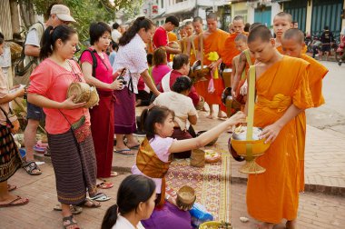 Luang Prabang, Laos - 15 Nisan 2012: Rahipler Luang Prabang, Laos 'taki günlük tören sırasında bağış ve bağış topluyorlar.