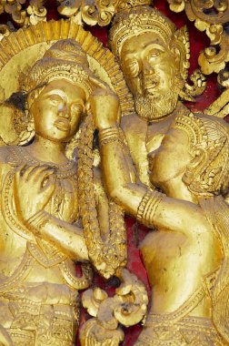 Luang Prabang, Laos - 16 Nisan 2012: Luang Prabang, Laos 'taki Wat Xieng Budist Tapınağı' ndaki antik altın dış duvar dekorasyonunun ayrıntıları.