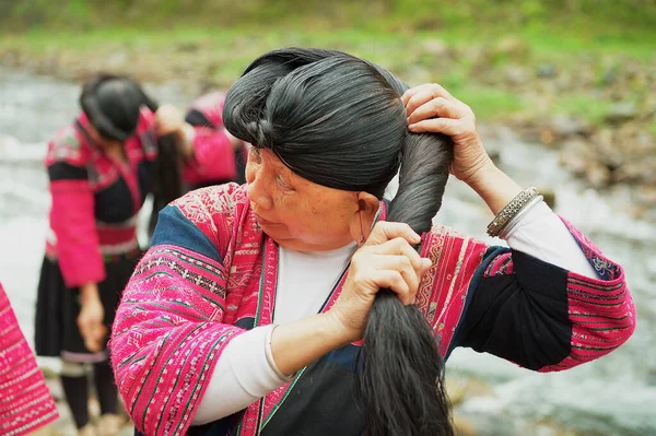 Longji 2009年5月6日 中国のLongjiで女性のブラシとスタイルの髪 紅八尾の女性桂林の周りLongji八尾村に住んでいる人々 中国は世界で最も長い髪の一つを持っています ロイヤリティフリーのストック画像