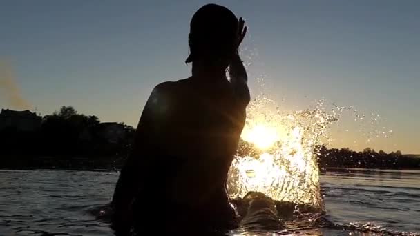 夕暮れ時の水と遊ぶ女性。スローモーション. — ストック動画