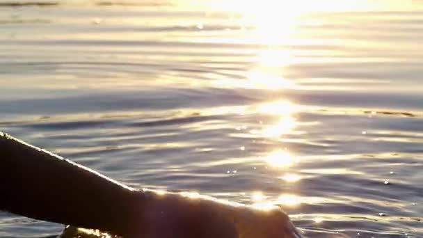 女孩的手握紧拳头的水。在日落时的慢动作. — 图库视频影像