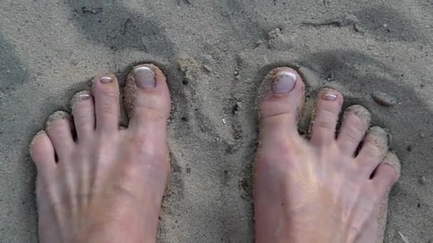 U nohou hrál s pískem na pláži. Pohled z vrcholu. — Stock video