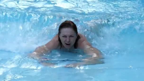 Gelukkige vrouw rustend in een kunstmatige bassin waarin golven zijn. Slow Motion. — Stockvideo