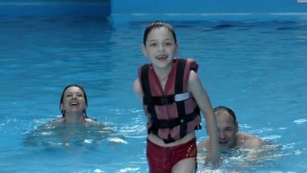 Glückliche Familie im Pool. Junge fuchtelt mit der Hand in Zeitlupe. — Stockvideo