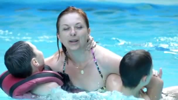 Szczęśliwa rodzina w basenie. Matka i dwóch chłopców. Uściski. — Wideo stockowe