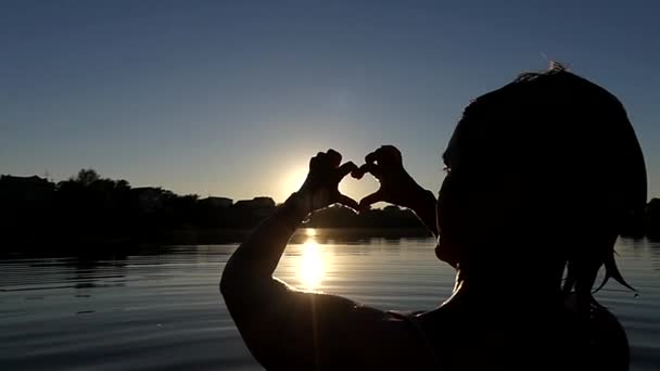 Woman 's Hands Show Heart at Sunset in Slow Motion . — стоковое видео