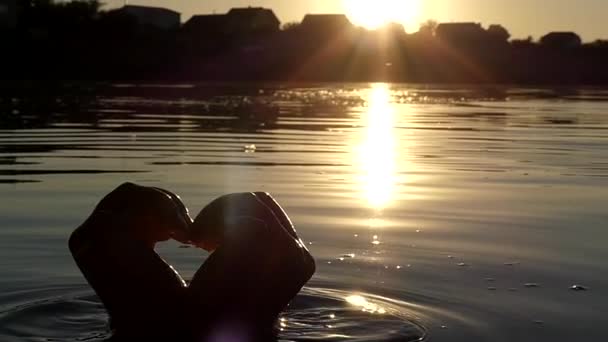 Les mains de la femme montrent le cœur au coucher du soleil au ralenti . — Video