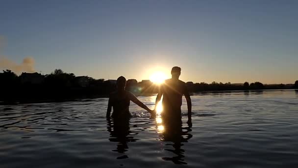 Hombre y mujer sosteniendo las manos para nadar en el lago. Moción lenta . — Vídeos de Stock