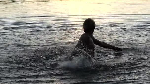 Человек играет с водой, чтобы создать всплески в медленном движении . — стоковое видео
