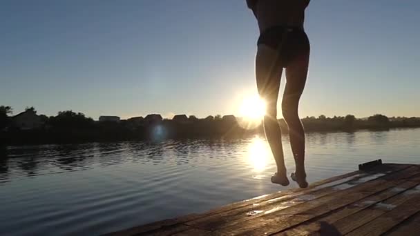 Muž, skokem do jezera v pomalém pohybu při západu slunce. — Stock video