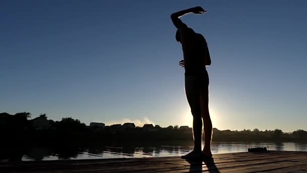 Professionele zwemmer maken oefeningen voor aanvang. de actie op het meer bij zonsondergang. — Stockvideo