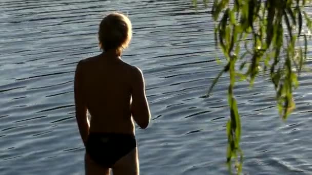 Un hombre medita mientras está parado en el agua . — Vídeos de Stock