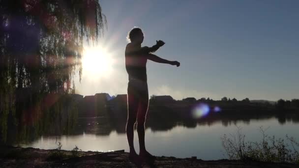 Nadador profesional hace ejercicios con las manos al atardecer en tiempo real . — Vídeos de Stock