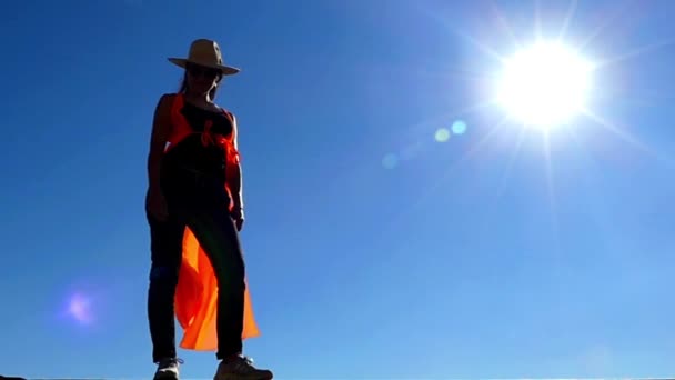 Rapariga de cowboy e chapéu de manto fica na luz do sol sobre o vento. Movimento lento . — Vídeo de Stock