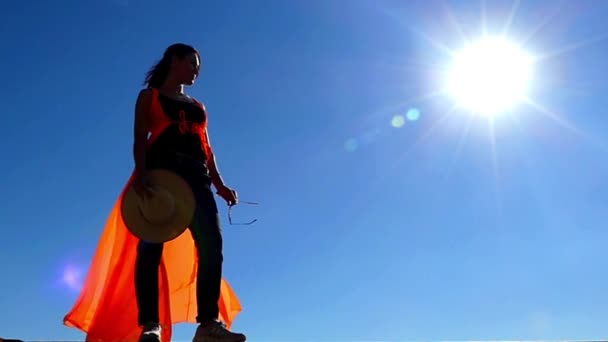 Chica con sombrero de vaquero en la mano de pie en la luz del sol. Moción lenta . — Vídeos de Stock