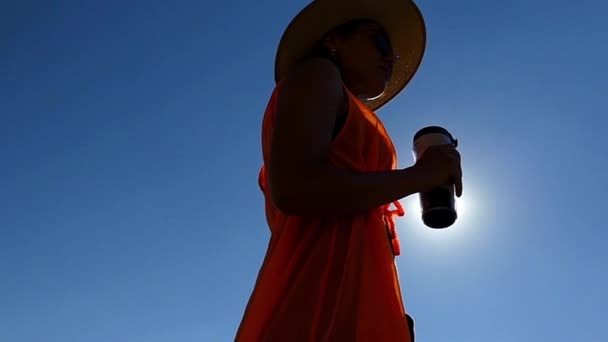 Dívka v Kovbojovém klobouku pije kávu v pomalém pohybu. Odpočívá na slunečních světlech. — Stock video