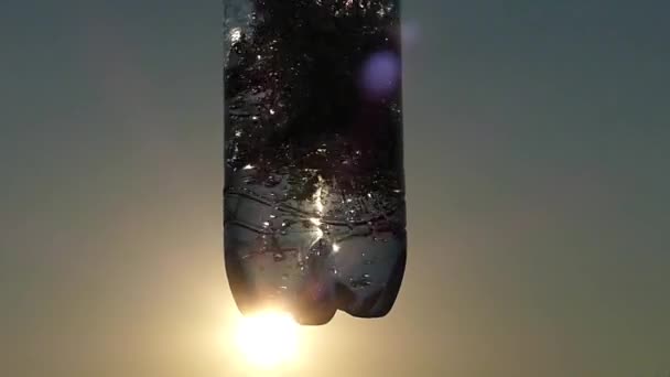 Láhev vody při západu slunce ve sluneční světlo. Zpomalený pohyb. — Stock video