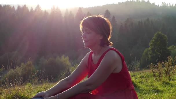 Piękna kobieta rozmawia przez telefon, w górach na zachodzie słońca. — Wideo stockowe