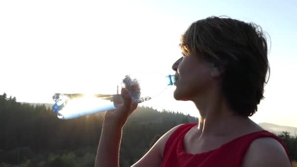 Silueta de mujer que bebe agua en cámara lenta y sonriente . — Vídeos de Stock