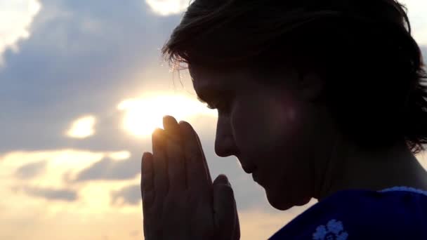 Silueta de la mujer rezando al atardecer . — Vídeo de stock